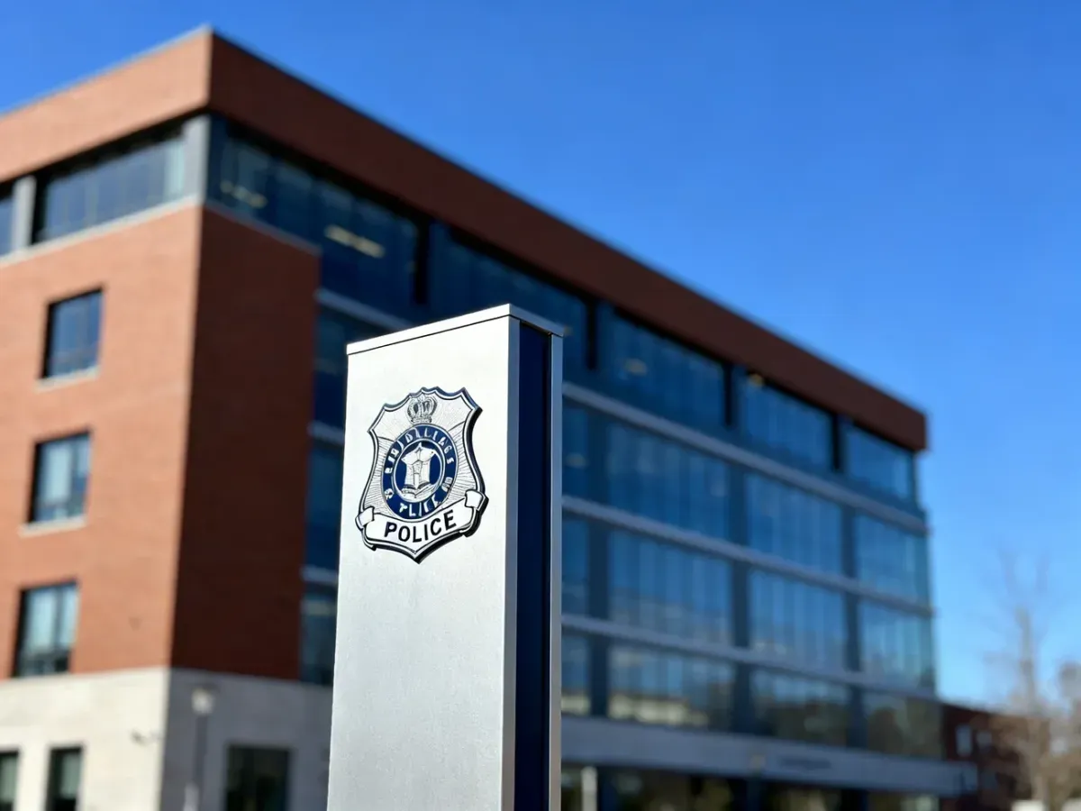 Nowoczesny budynek Komisariatu Policji Poznań-Nowe Miasto z widocznym znakiem policyjnym na pierwszym planie.