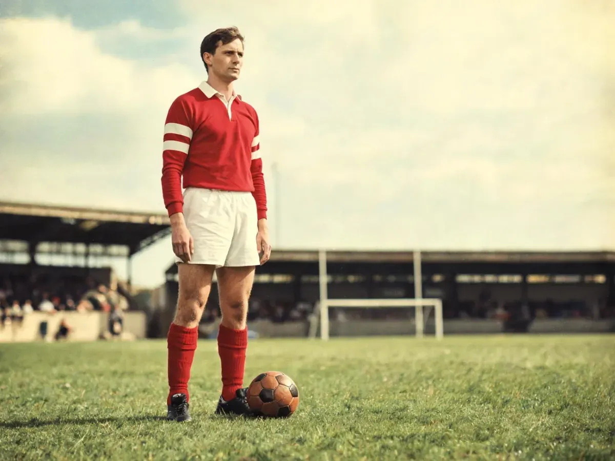 Hieronim Barczak na boisku w klasycznym czerwono-białym stroju, przy starej piłce, w nostalgicznej, retro scenerii stadionu