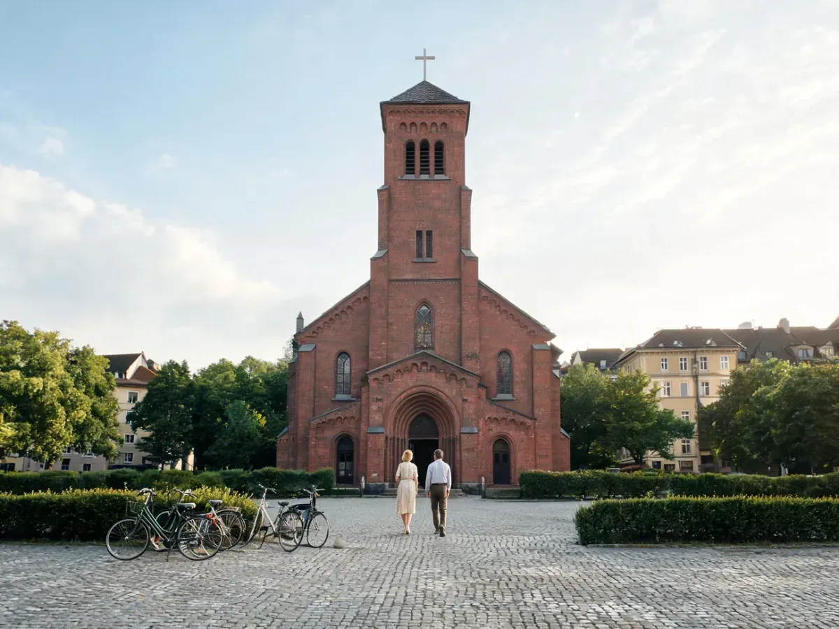 Zabytkowy ceglany kościół św. Jakuba w Poznaniu, widok od frontu z wiernymi wchodzącymi na spokojny plac przed świątynią