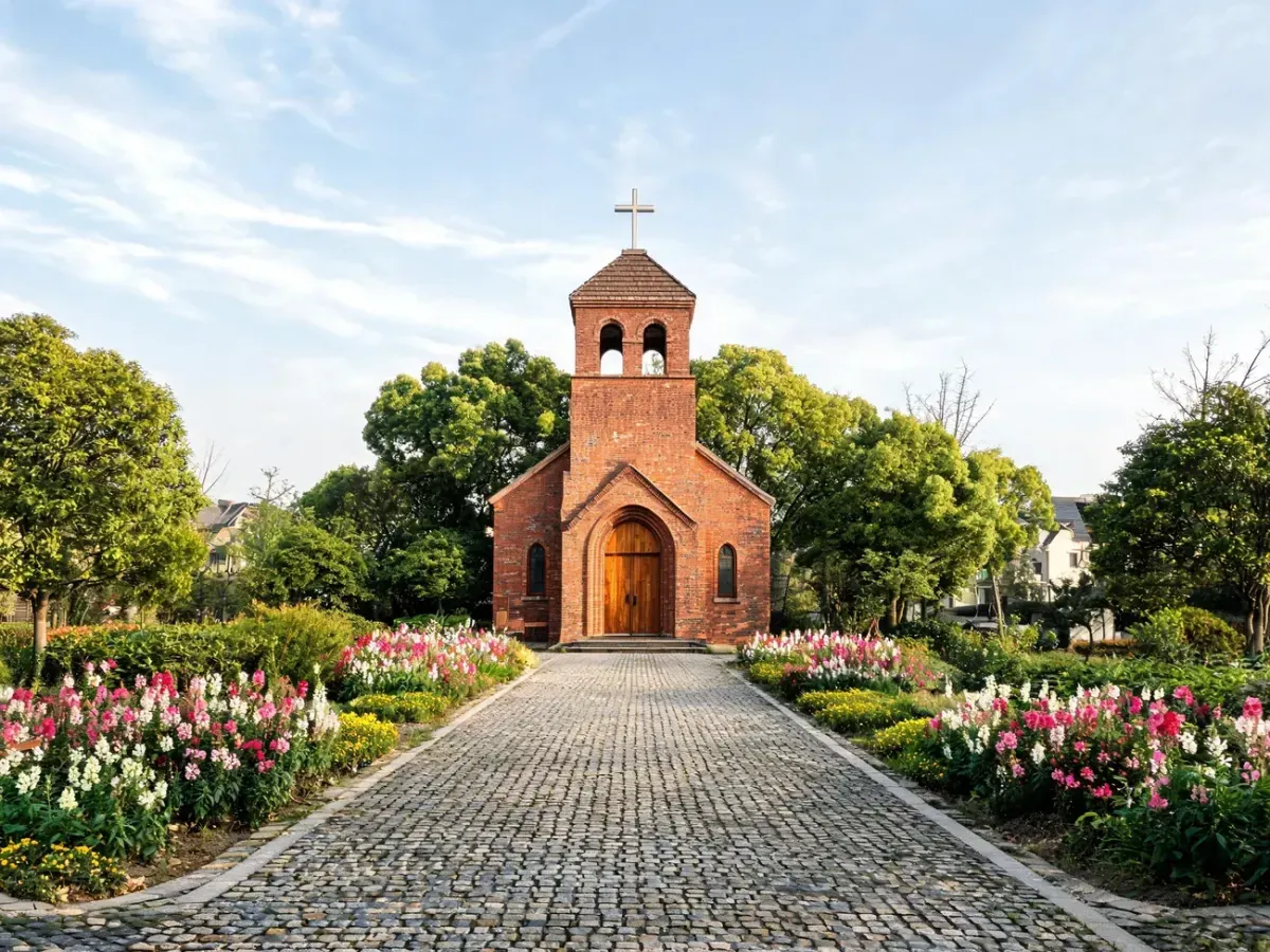 Kościół św. Jadwigi Śląskiej w Poznaniu, widok frontowy w słoneczny dzień, otoczony zielenią i kwiatami.